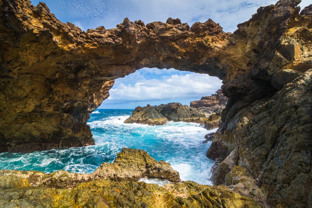 Aruba Natural Bridge – Scenic Rock Formation on the Island's East Coast Natural rock bridge on Aruba's rugged east coast with waves crashing below