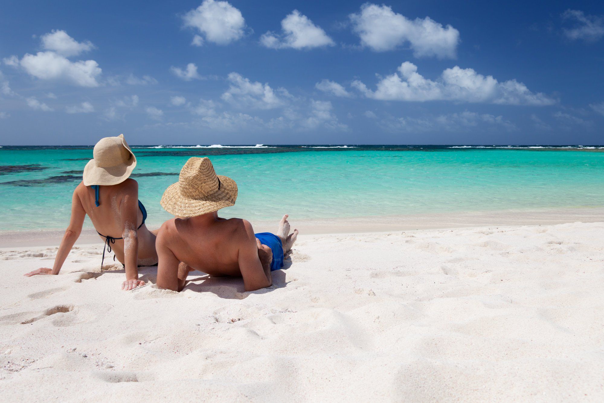 Aruba Travel Tips – Essential Advice for a Smooth & Enjoyable Trip Couple relaxing on a white-sand beach in Aruba with turquoise water and blue sky
