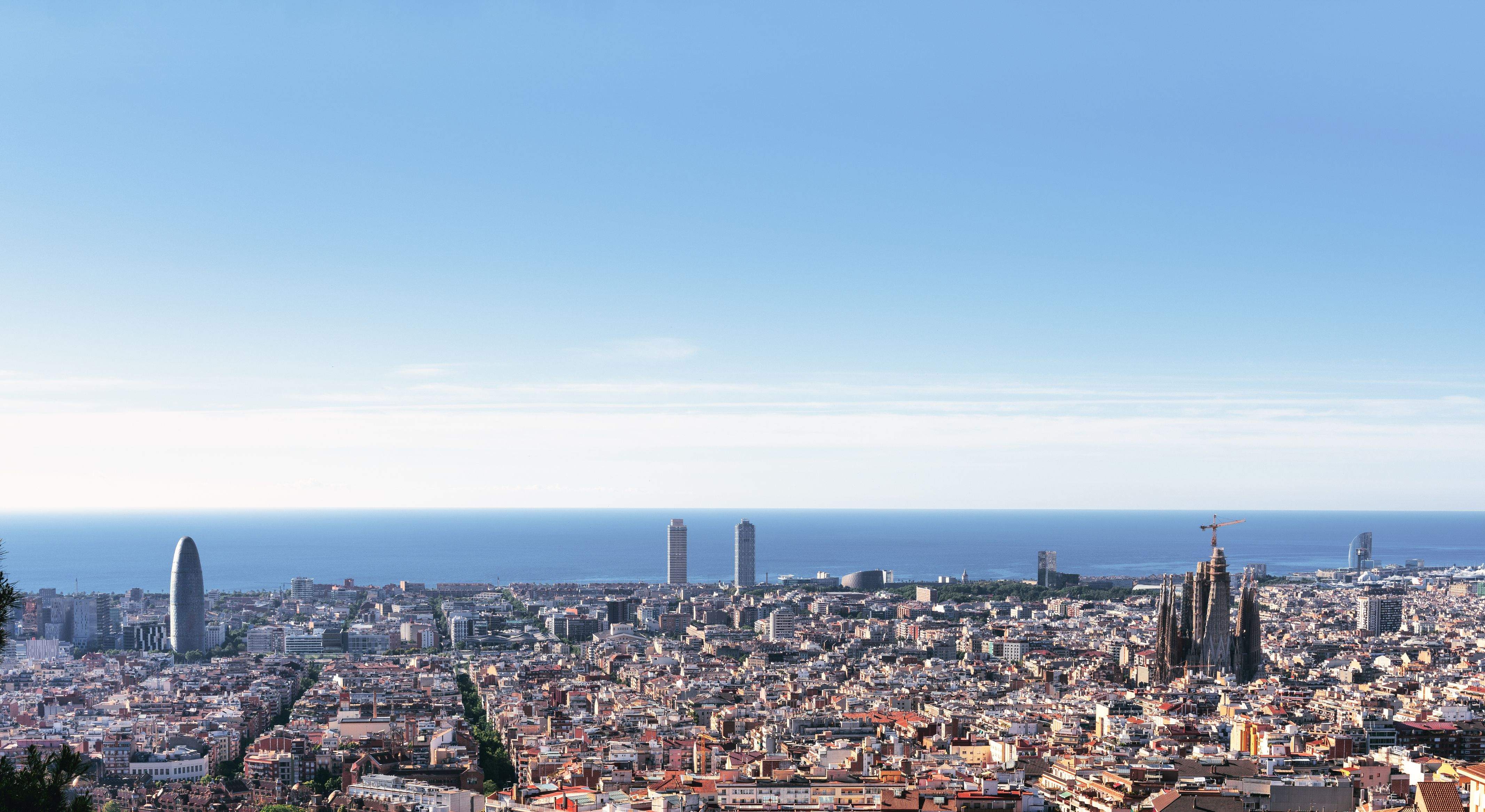 About Barcelona – Mediterranean Culture, Architecture and Coastal Lifestyle Panoramic view of Barcelona with Sagrada Familia, the Mediterranean Sea and the modern city skyline under a clear sky