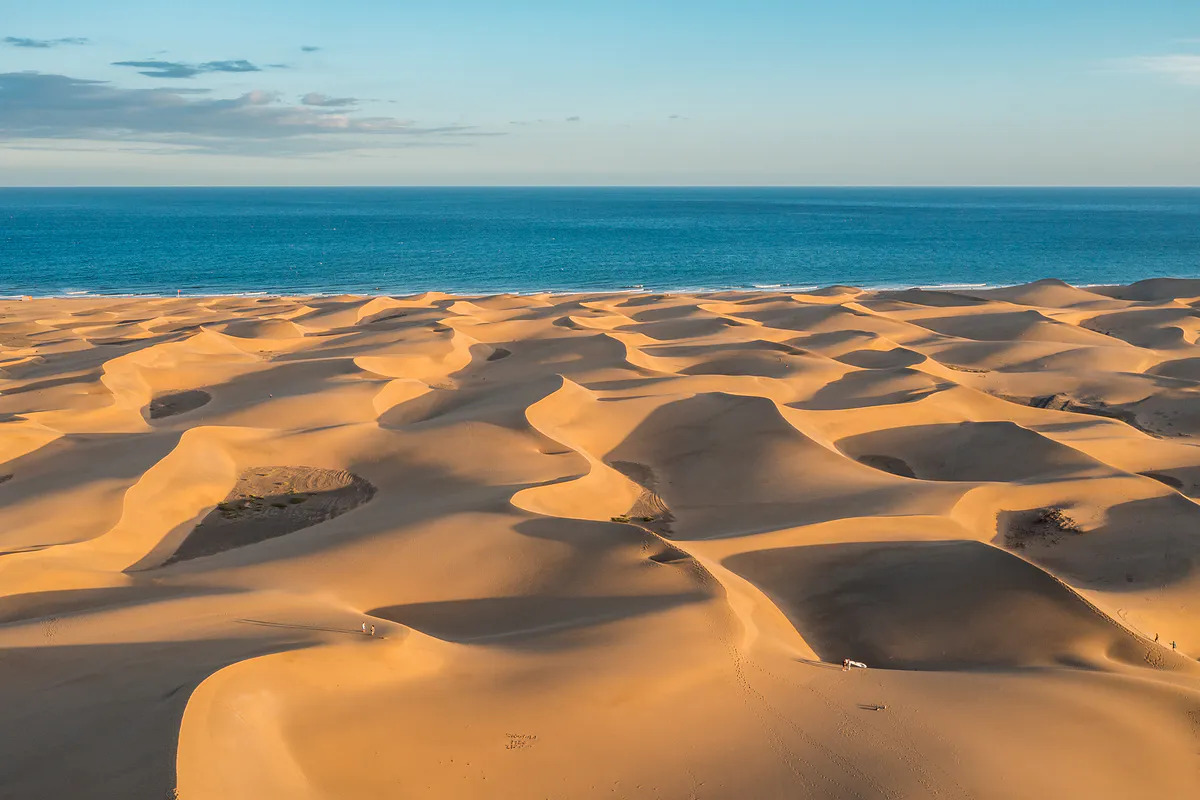 The golden dunes of Maspalomas are one of the Canary Islands’ most iconic landscapes Maspalomas dunes stretching toward the Atlantic Ocean