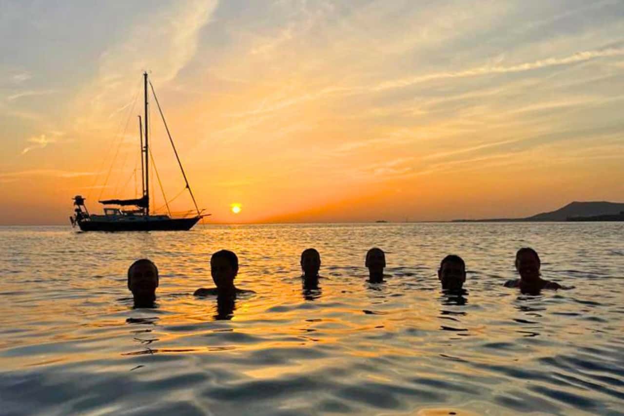 The Canary Islands combine dramatic sunsets, calm seas and year-round mild weather Sunset over a beach in the Canary Islands with silhouettes of people and boats