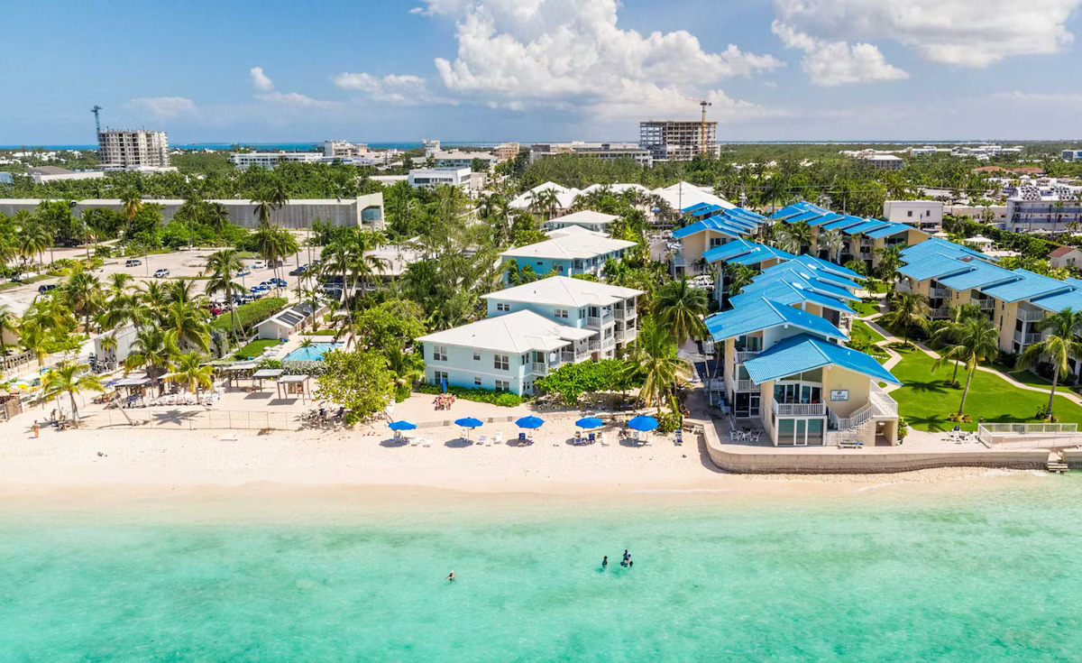 Where to Stay in the Cayman Islands – Hotels, Resorts and Best Areas Aerial view of beachfront resorts and condos along Seven Mile Beach in Grand Cayman with turquoise waters