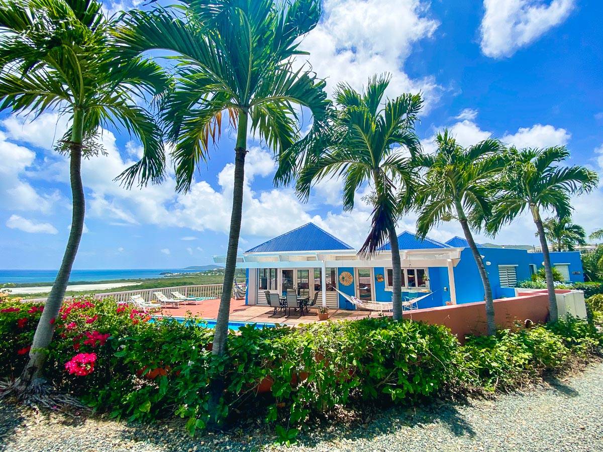Island Villas – Space and Privacy Hillside villa with palm trees, outdoor terrace and pool views in a tropical island setting