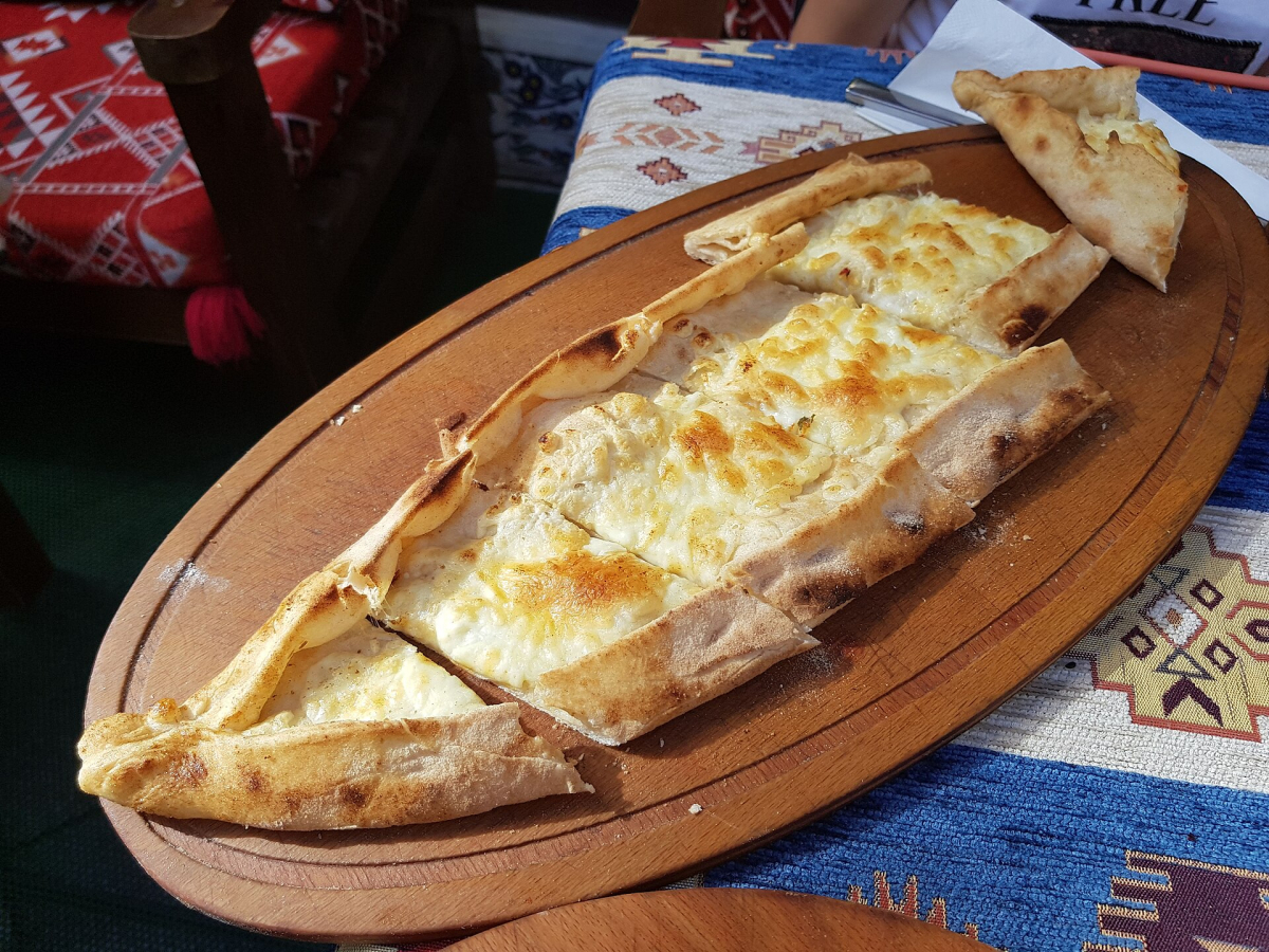 Cheese pide served on a wooden board in an Istanbul restaurant Cheese pide served on a wooden board in an Istanbul restaurant