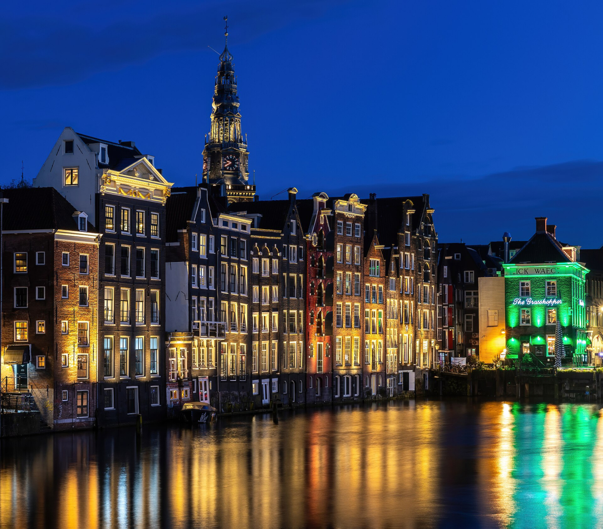 Illuminated canal houses and the Oude Kerk skyline at Damrak. Illuminated canal houses and the Oude Kerk skyline at Damrak.