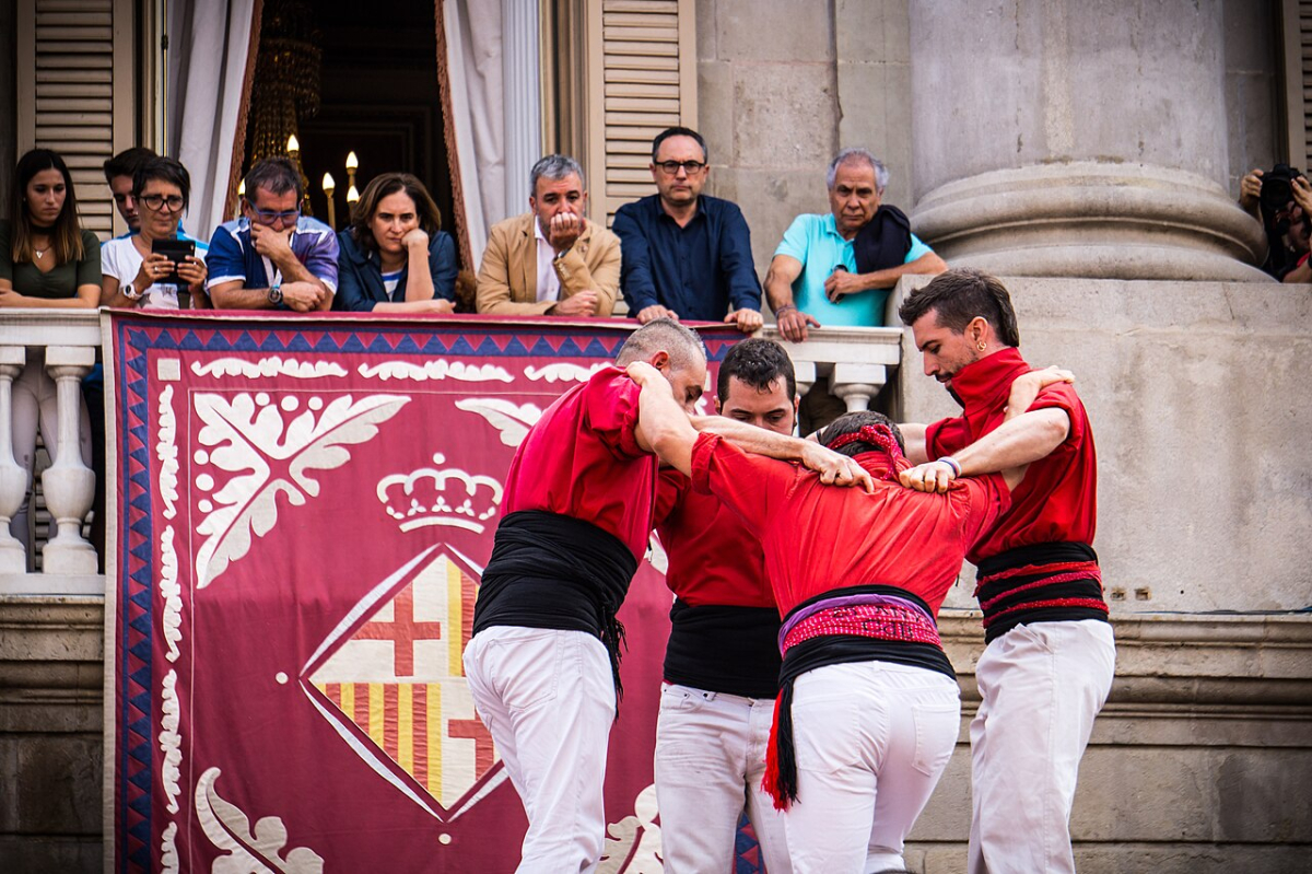 Castellers in red shirts preparing a formation during La Mercè in Barcelona Castellers in red shirts preparing a formation during La Mercè in Barcelona
