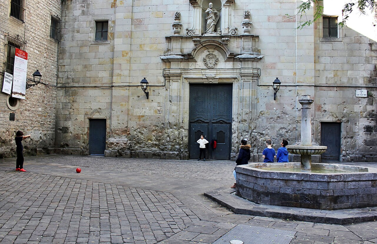 Church facade and fountain in Plaça Sant Felip Neri in Barcelona Church facade and fountain in Plaça Sant Felip Neri in Barcelona
