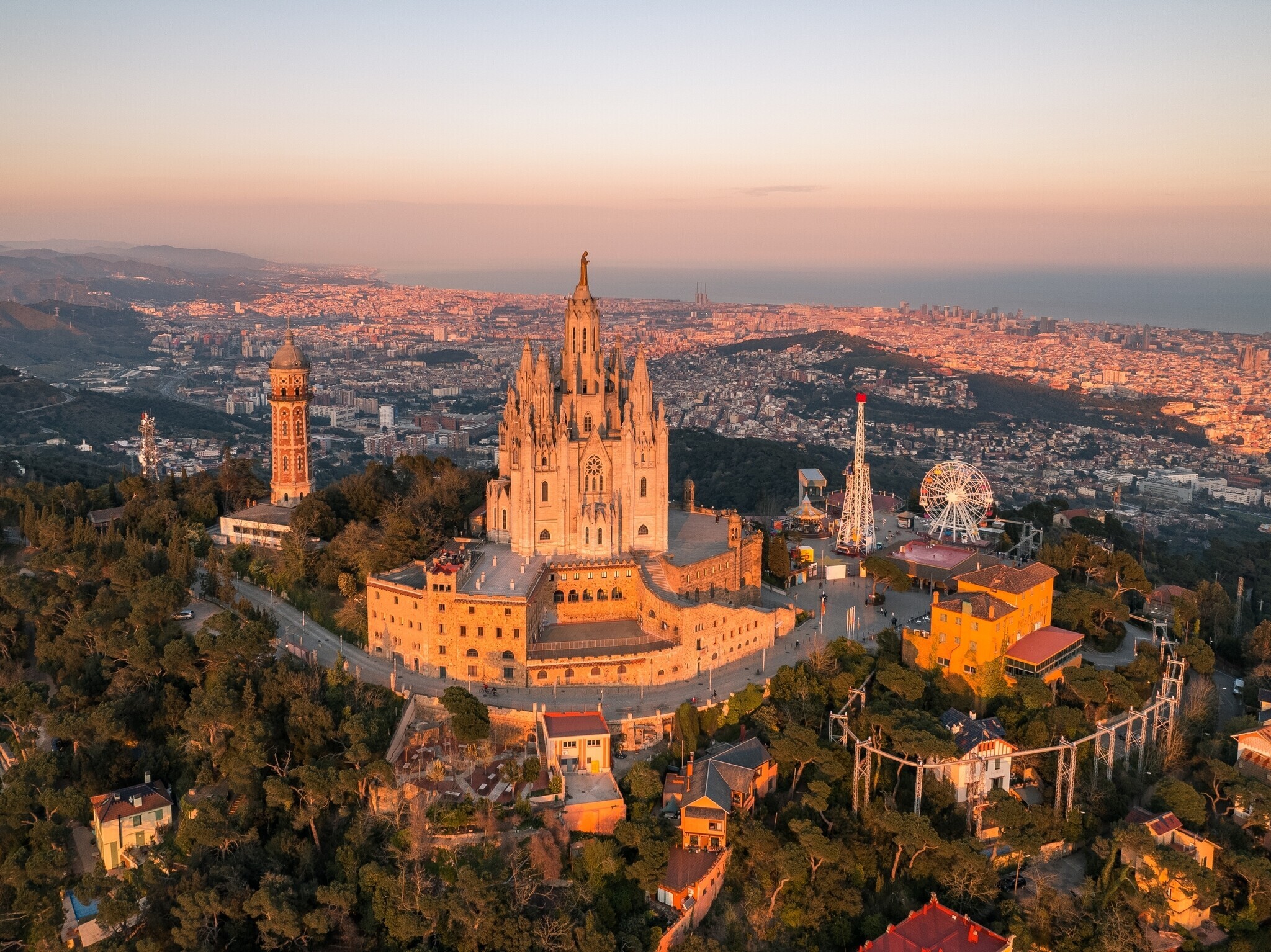 Things to Do in Barcelona – Top Attractions and Memorable Experiences Aerial view of Tibidabo and Sagrat Cor church overlooking Barcelona city and the Mediterranean Sea